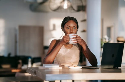 Mulher fazendo uma pausa reflexiva com uma xícara de café