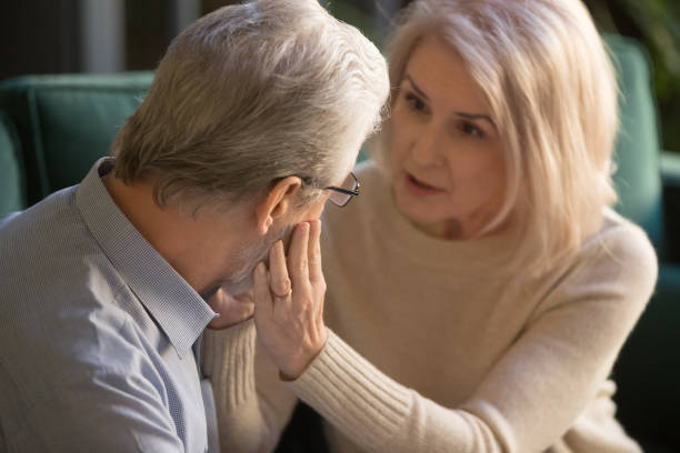Mulher mais velha consolando um homem em um momento de perdão e cura